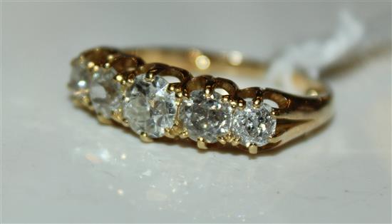 An early 20th century unmarked gold and graduated five stone half hoop ring, size K.